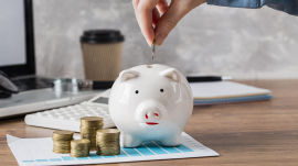 hand-putting-coin-piggy-bank-growth-chart