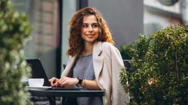 Young business woman working on a computer outside the cafe